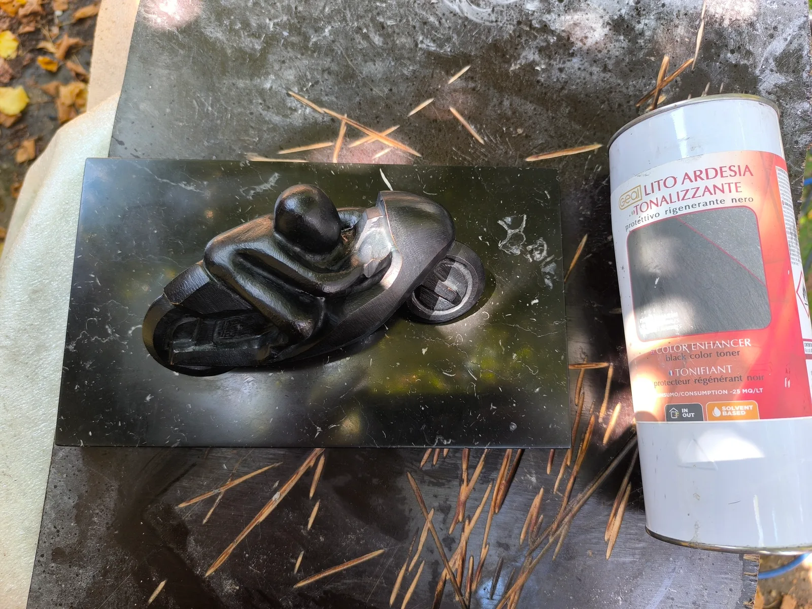 Sculpture de motard en marbre noir après restauration, finition brillante miroir